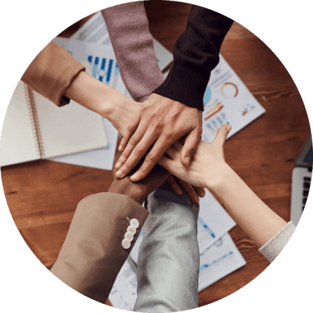 Mãos de pessoas agrupadas em formato circular, cada uma das mãos está em cima da outra, e aqui, isso transmite a ideia de união da equipe Master Proficiency.